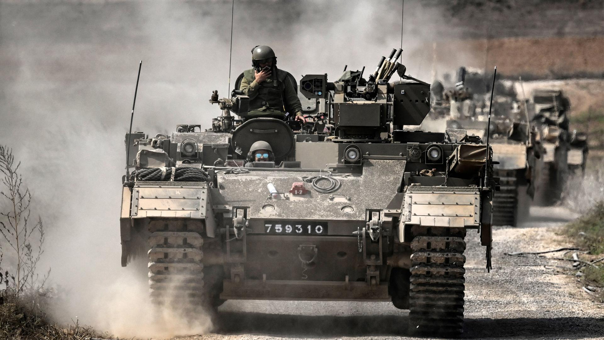 Israelische Soldaten fahren in einer Kolonne mit gepanzerten Fahrzeugen nahe der Grenze zu Gaza im Süden Israels